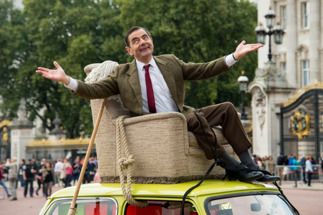 British actor Rowan Atkinson, dressed as Mr Bean, sits on top of a Mini Cooper outside Buckingham Palace, London, to promote the 25th anniversary of Mr Bean, London, Friday, Sept. 4, 2015. (Photo by Jonathan Short/Invision/AP)