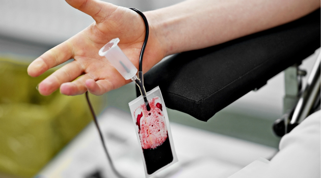 Detail with the hand of a blood donor and a plastic blood bag in a hospital