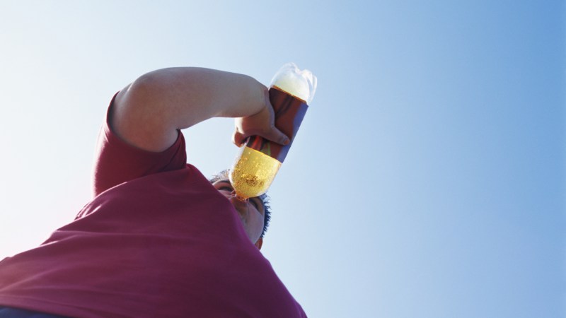 Overweight Teenage Man Drinking From a Bottle