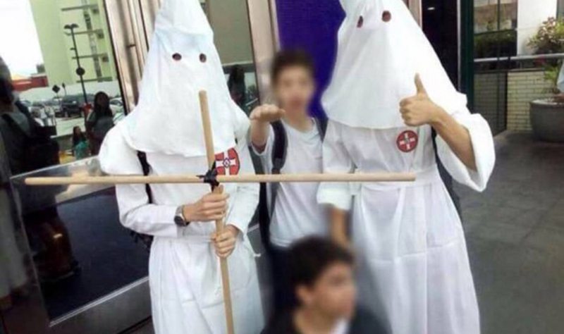 Na atividade do Mico, alunos do Colégio Anchieta aparecem com roupas brancas e fazendo sinal nazista (Foto: Facebook/Reprodução)