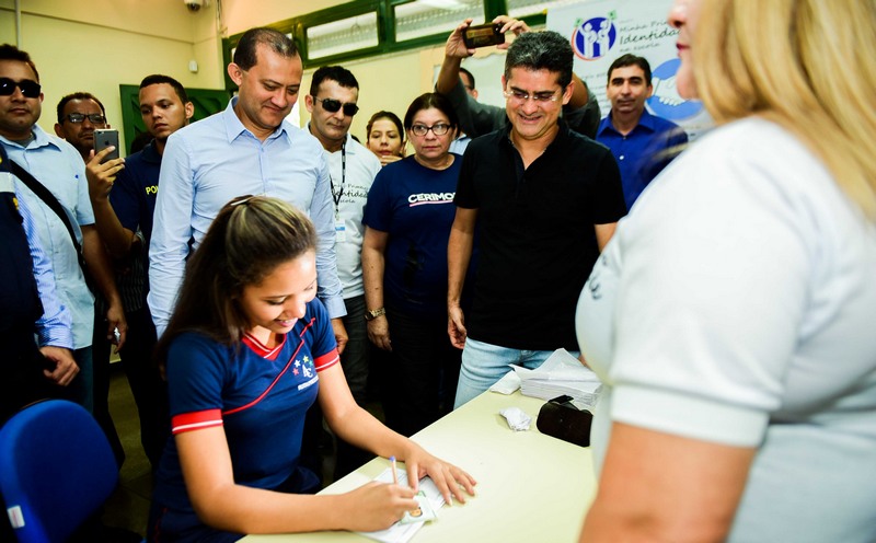 Governador David Almeida acompanha aluna a assinar primeira identidade em programa do governo do Estado (Foto: Valdo Leão/Secom)