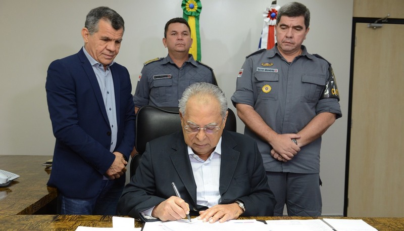 Governador Amazonino Mendes assina promoção de policiais militares observado por secretário de Segurança, Bosco Saraiva, e comandante da PM, David Brandão (Foto: Clóvis Miranda)