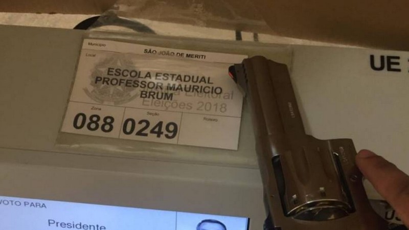Arma aparece em cima de uma urna na Escola Estadual Professor Mauricio Brum, em São João do Mereti, no Rio de Janeiro (Foto: Twitter/Reprodução)