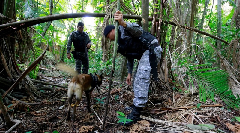 Policial militar busca restos de corpos enterrados em área da zona centro-sul de Manaus usado para enterrar vítimas de assassinatos (Foto: SSp-AM)