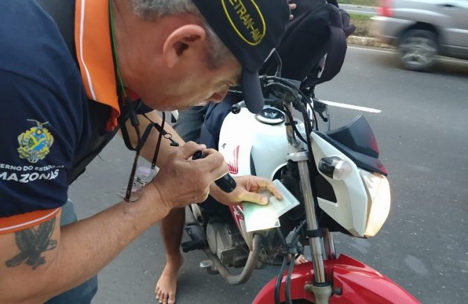 Agente de trânsito confere documento sobre registro de moto: fiscalizar maior durante o carnaval (Foto: Paulo Bahia Jr./Detran-Divulgação)