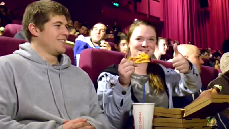 Expectadores com pizza em cinema (Foto: YouTube/Reprodução)
