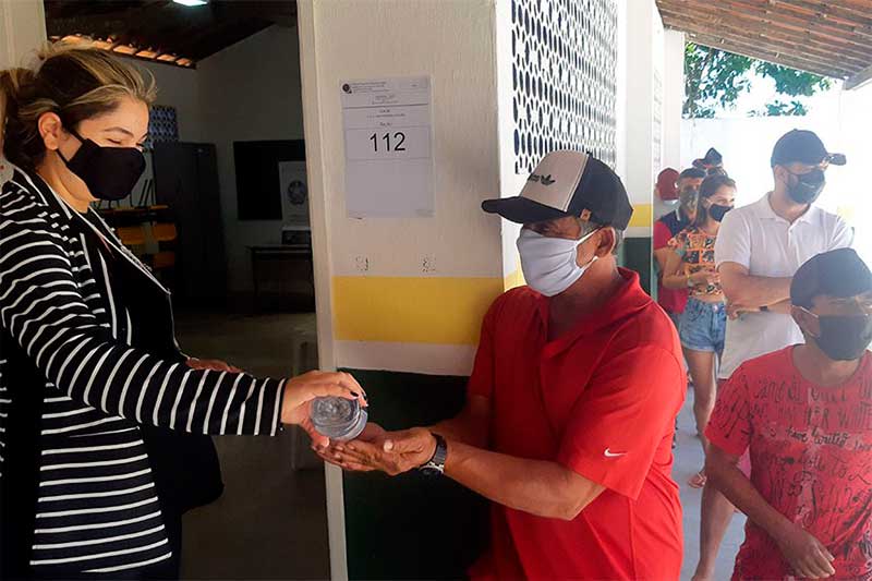 Eleitor recebe álcool em gel em seção eleitoral: de volta às urnas (Foto Marcos Oliveira/Agência Senado)