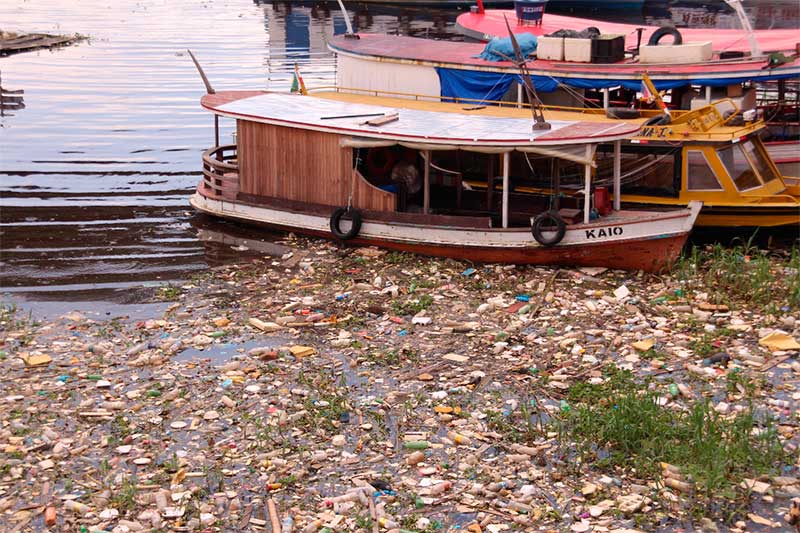 Barcos em meio ao lixo na orla do Rio Negro: paisagem comum (Foto: Walter Calheiros)