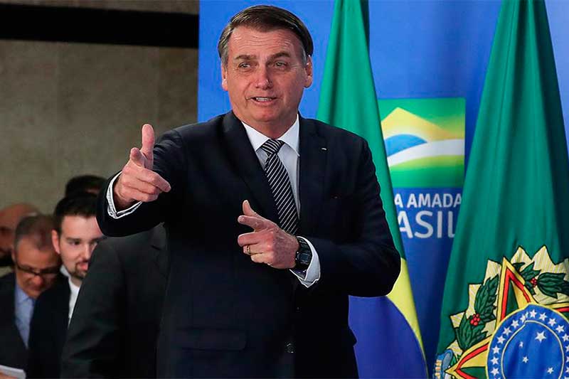 Presidente Jair Bolsonaro faz gesto de arma: novo slogan religioso (Foto: Marcos Corrêa/PR)