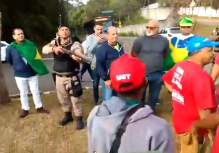 Policial Militar aponta arma para manifestantes em Juiz de Fora IFoto: Reprodução/Twitter)