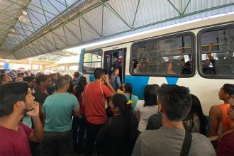 Passageiros ficam pendurados na porta de ônibus (Foto: Felipe Campinas/ATUAL)