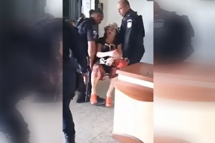 Mulher é levada em cadeira ao resistir à detenção (Foto: Redes sociais/Reprodução)