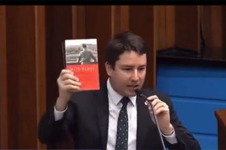 João Henrique Catan gerou polêmica ao exibir livro de Hitler (Foto: TV Assembleia-MT/Reprodução)