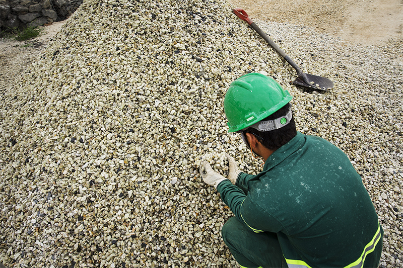 Auxiliar de mineração mostra minérios de espodumênio, de onde se obtém o lítio (Foto: Eduardo Knapp/Folhapress)