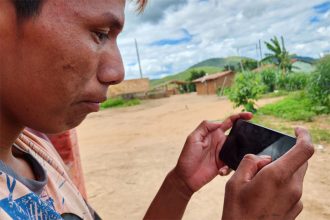 Indígena Maxakali acessa internet no celular: mundo nas mãos (Foto: UFMG/Divulgação/Arquivo pessoal)