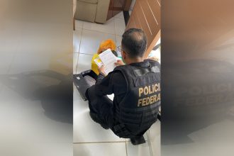Agente federal inspeciona documentos em operação contra manipulação de resultados no futebol (Foto: PF/Divulgação)
