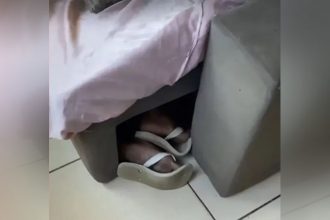 Foragido deixou pé de fora ao se esconder embaixo de sofá (Foto: Redes sociais/Reprodução)