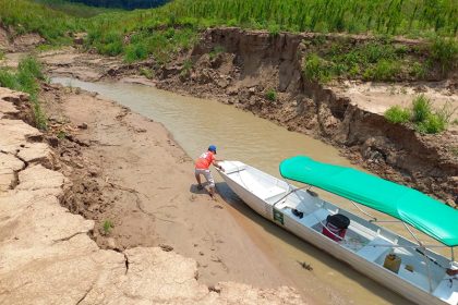 Barcos pequenos são puxados por córrego com o que restou de água no Amazonas (Foto: Defesa Civil/Envira/Divulgação)