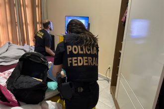 Agentes federais inspecionam computador e recolhem documentos em casa de suspeito em Rio Preto da Eva (Foto: PF/Divulgação)