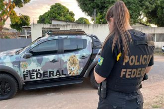 Agente da PF em frente à casa de suspeito: busca em operação contra desvio de medicamentos (Foto: PF/Divulgação)