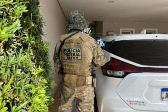 Agente federal em casa de suspeito de tráfico: procurados pela Interpol (Foto: PF/Divulgação)