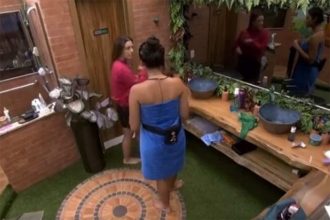 Alane (de toalha) alerta Beatriz sobre aviso no banheiro (Imagem: Globoplay/Reprodução)
