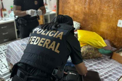 Agente federal procura documentos em casa de suspeito de fraude no INSS (Foto: PF/Divulgação)