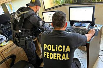 Agentes federais inspecionam computador e documentos em casa de suspeito (PF/Divulgação)