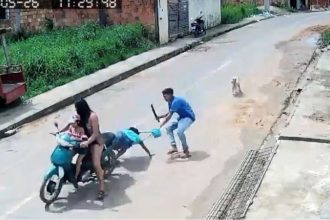 Momento em que o suspeito puxa a mulher da garupa de uma motocicleta para assaltá-la (Imagem: Reprodução/Redes sociais)