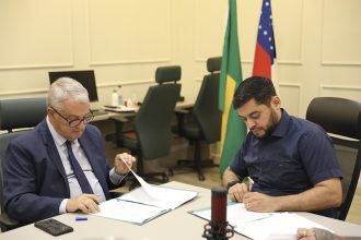 Oswaldo Jodas, da Funtec, e o reitor André Zogahib assinam acordo para transmissão do Pré-Vest (Foto: Gustavo Rodrigues/UEA)