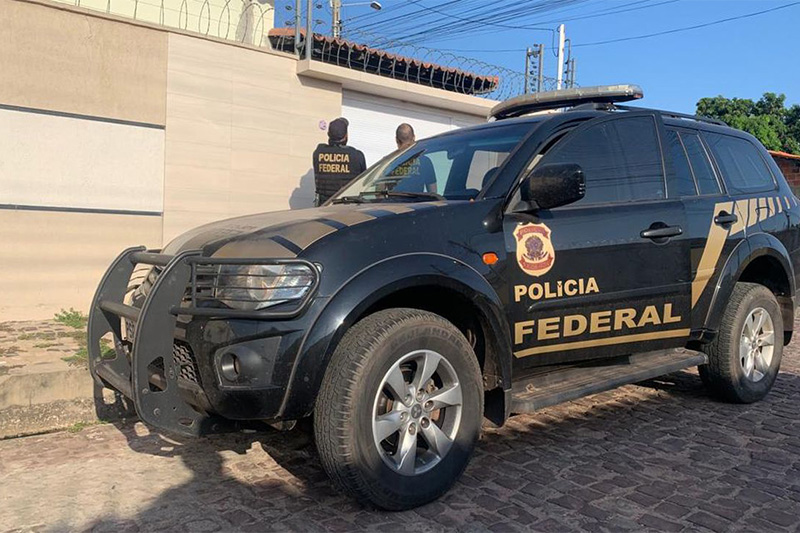 Agentes federais em casa de suspeito: busca por criminosos que ameaçam servidores (Foto: PF/Divulgação)