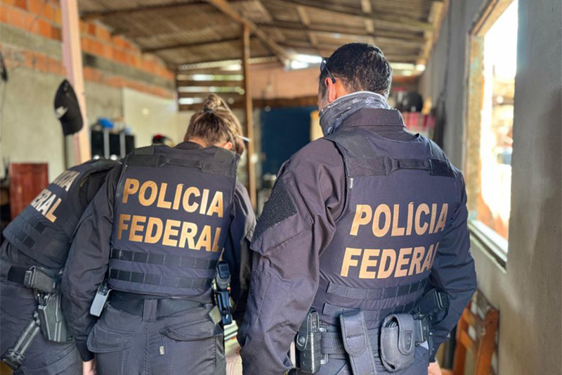 Policiais federais inspecionam material encontrado na casa do suspeito de estupro e pornografia infantil (Foto: PF/Divulgação)