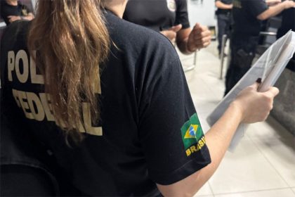Agente federal inspeciona documento em casa de suspeito de pedofilia (Foto: PF/Divulgação)