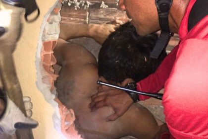 Homem ficou preso entre as paredes de duas casas (Foto: Divulgação/Bombeiros)
