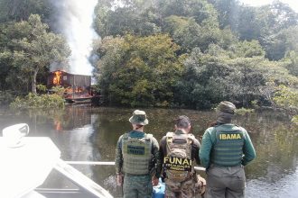 Agentes do Ibama e Funai observam draga de garimpo pegar fogo: 31 foram destruídas no Rio Madeira Foto: Ibama/Divulgação)