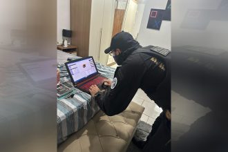 Agente federal inspeciona notebook em casa de suspeito: combate à pedofilia (Foto: PF/Divulgação)