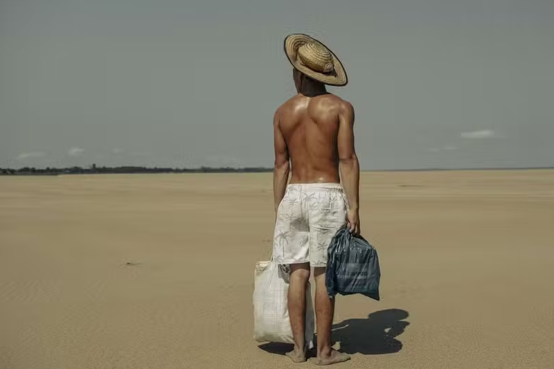 Homem carrega alimentos em leito seco de rio em Manacapuru: imagem da seca na Amazônia (Foto: Musuk Nolte/Panos Pictures)
