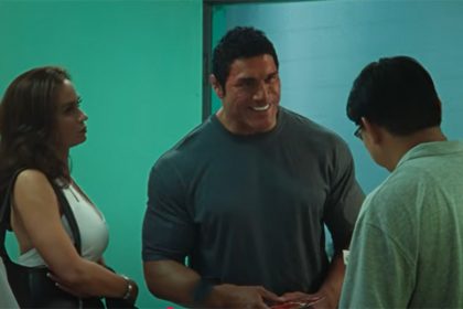 Emily Blunt com Dwayne Johnson em cena de Coração de Lutador: transformação pela maquiagem (Imagem: YouTube/trailer/Reprodução)