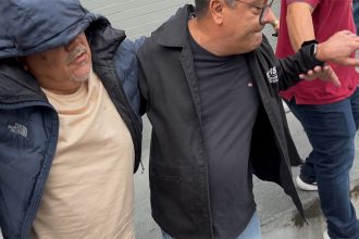 Antônio Marcio Silva de Castro (com casaco de capuz) foi preso ao se apresentar à polícia (Imagem: WhatsApp/Reprodução)