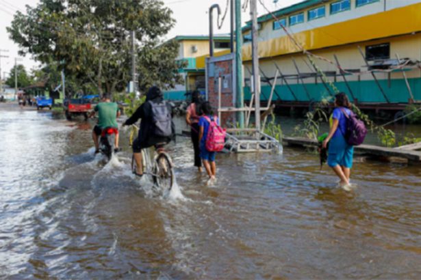 Alunos andam em rua alagada: cheia afeta ensino público no interior do Amazonas (Foto: Antônio Lima/Secom Gov. AM)