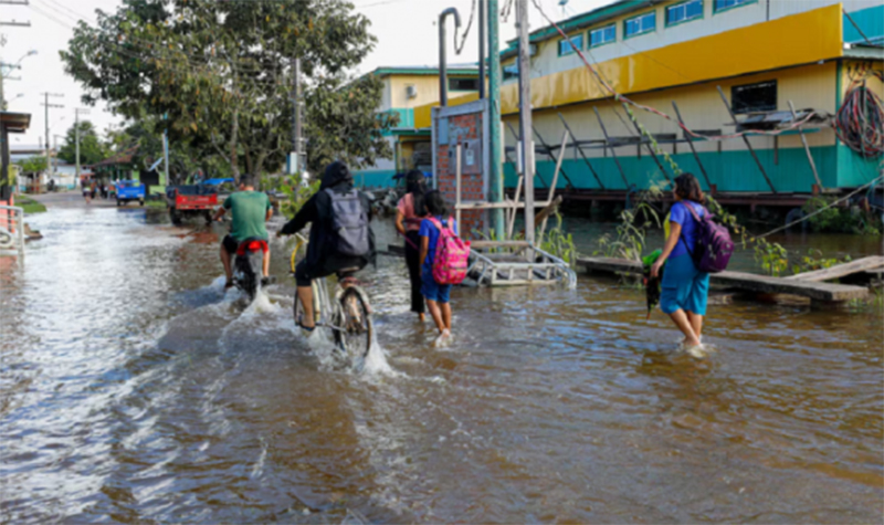 Alunos andam em rua alagada: cheia afeta ensino público no interior do Amazonas (Foto: Antônio Lima/Secom Gov. AM)