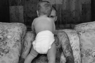 Cantor Justin Bieber aparece com um bebê em foto de divulgação do novo álbum (Foto: Justin Bieber/Divulgação)