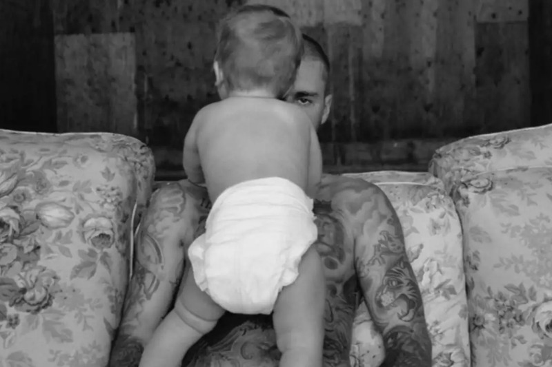 Cantor Justin Bieber aparece com um bebê em foto de divulgação do novo álbum (Foto: Justin Bieber/Divulgação)