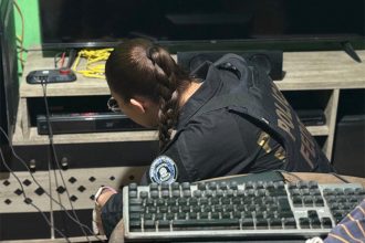 Agente federal inspeciona computador e vídeo de suspeito de abuso sexual infantil (Foto: PF/Divulgação)