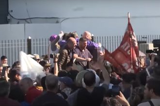 Seguranças protegeram Javier Milei de pedras atiradas contra ele (Imagem: SBT News/YouTube/Reprodução)