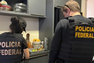 Agentes federais recolhem documentos em casa de suspeito de fraude (Foto: PF/Divulgação)
