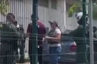 Policiais conversam com professora: bandidos atiraram nos alunos pela grade do muro da escola (Imagem: WhastApp/Reprodução)