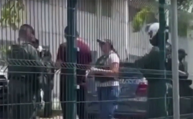 Policiais conversam com professora: bandidos atiraram nos alunos pela grade do muro da escola (Imagem: WhastApp/Reprodução)