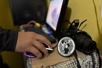 Agente federal inspeciona computador apreendido de suspeito em Manaus (Foto: PF/Divulgação)