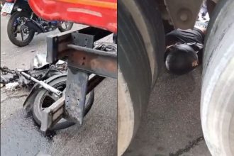 Motociclista e passageiro ficaram desacordados embaixo da carreta (Foto: WhatsApp/Reprodução)